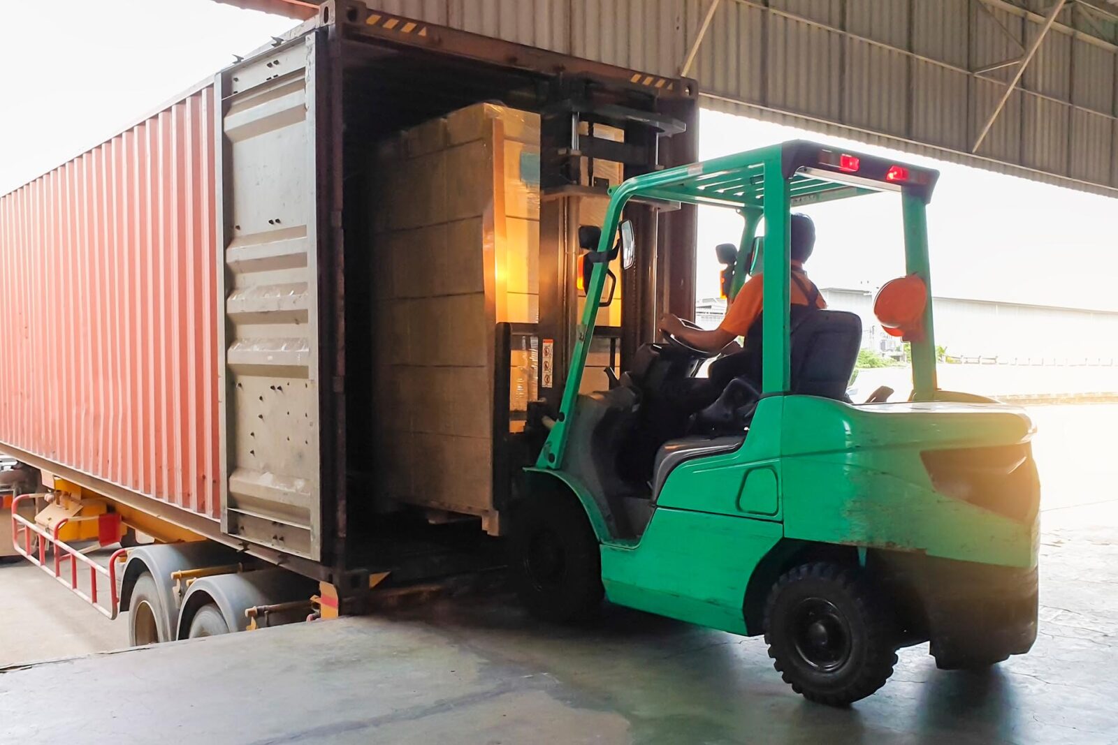 Forklift,Tractor,Loading,Package,Boxes,Into,Shipping,Container,At,Dock